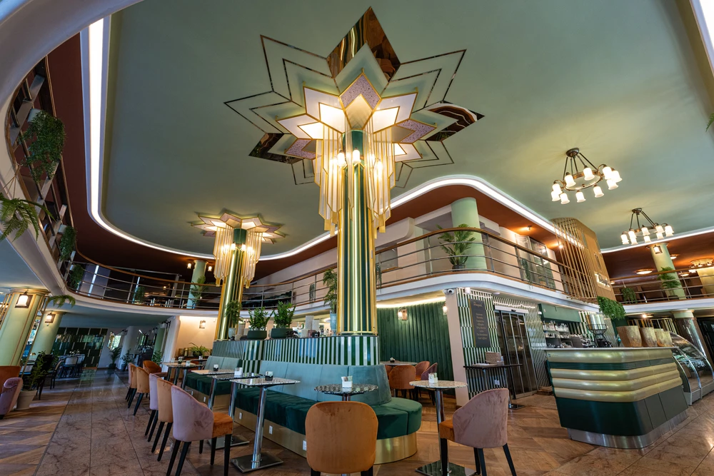 A Dunapark Kávéház ikonikus art deco enteriőrje díszoszlopokkal és elegáns galériás vendégtérrel Budapesten